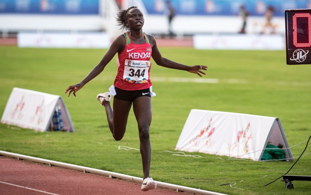 Kenyan track athlete running at full speed during an Athletics Kenya competition, emphasizing sprint performance.